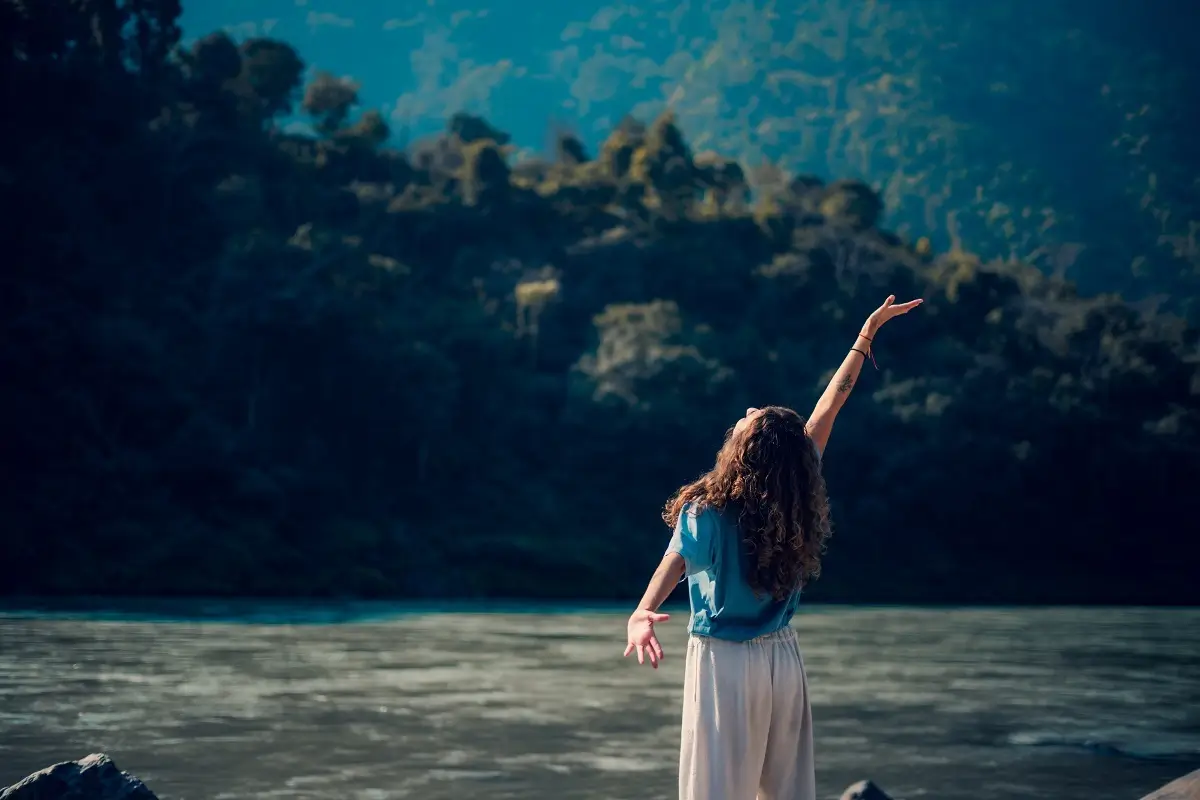 Group yoga class practising Warrior pose outdoors at a retreat in Rishikesh, India
